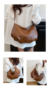 Brown half-moon tote bag with logo patch and decorative white fur ball pendant