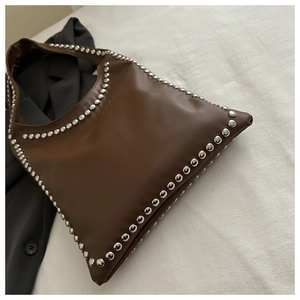 Detailansicht der dunkelbraunen Lederschultertasche mit dekorativen silbernen Metallnieten