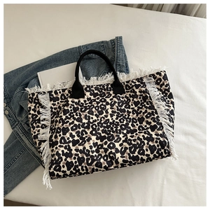 Detalle del bolso tote con estampado de leopardo, flecos blancos y asas de lona