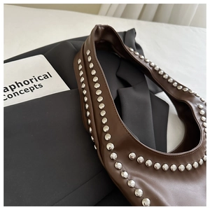 Detailansicht der braunen Hobo-Tasche mit silbernen Nieten und Lederstruktur im Vintage-Stil