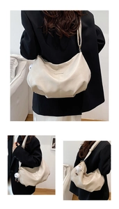 Detail of minimalist beige faux leather shoulder bag with plush pendant and wide strap