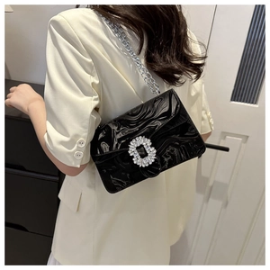 Details der schwarzen Wellenstruktur-Handtasche mit Kristallschnalle und Silberkette