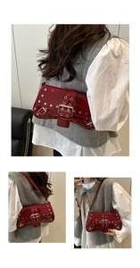 Detail of red patent leather shoulder bag with silver rivets and buckle in Y2K style
