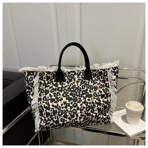 Detalle de bolso tote con estampado de leopardo y flecos en silla de metal