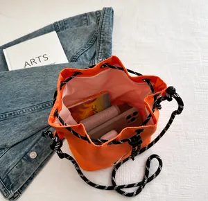 Primer plano del bolso saco de nailon naranja con gran capacidad interior y cordón trenzado