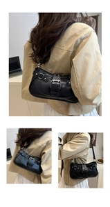 Detail der schwarzen Vintage-Hobo-Tasche aus Kunstleder mit Silberschnallen und Ösen