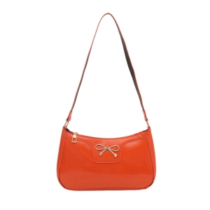 Chic orange patent leather baguette bag with a stylish gold bow accent and slim strap