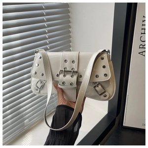 Close-up of white patent leather shoulder bag with silver studs and punk metal buckles