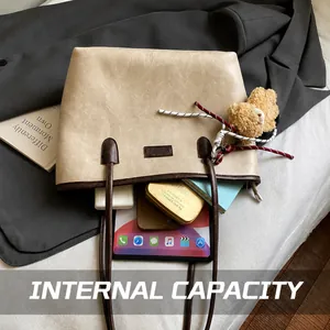 Detail shot showing the large interior capacity of the beige faux leather tote bag