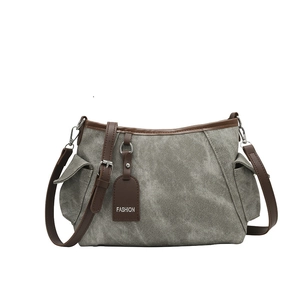 Gray canvas bucket bag with brown leather trim and side pockets for women's daily commute