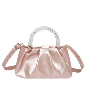 Pink metallic pleated cloud bag with pearl handle and shoulder strap in a front view