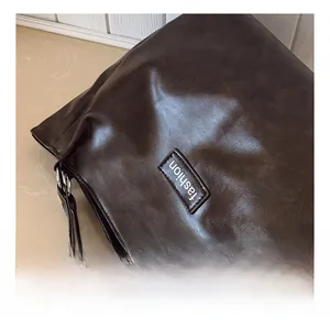 Detail view of deep brown leather tote showing vintage texture and fashion label