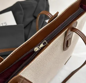 Detail of smooth gold zipper and high-quality canvas leather stitching on the tote bag