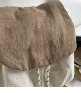 Close-up of contrast nylon backpack with drawstring and You Ji Bear logo detail