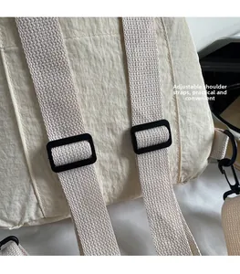 Close-up of adjustable strap on beige nylon backpack showing functional buckles
