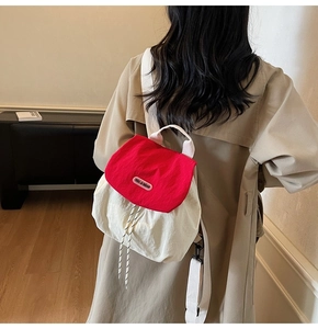 Detail of red and white contrast mini backpack with drawstring and brand logo print