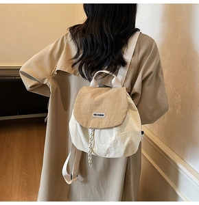 Detail of contrast canvas backpack with drawstring closure and brand label on flap
