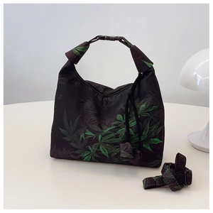 Detail of black crescent hobo bag with green leaf print and adjustable shoulder strap