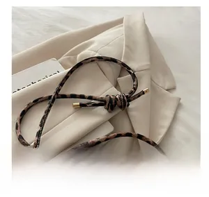 Detail of leopard print shoulder bag with knotted strap and refined metal tips