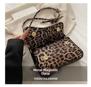 Close-up of leopard print shoulder bag featuring a premium golden magnetic snap closure
