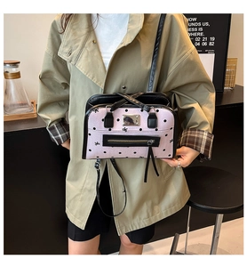 Rosa Handtasche mit Polka-Dots, Stickerei und Quasten von Model in Trenchcoat getragen