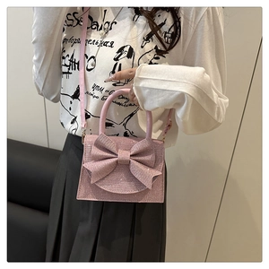 Dettaglio della borsa rosa glitterata con grande fiocco e tracolla rimovibile chic