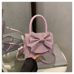 Dettaglio macro della borsa rosa con paillettes, fiocco e superficie luccicante