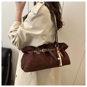 Detail der dunkelbraunen Wildleder-Tote-Bag mit Ethno-Holzperlen und Metallschnalle