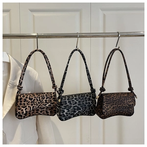 Three vintage leopard print shoulder bags with unique side knot details on white door