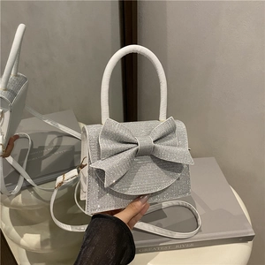 Elegante borsa con paillettes argento con grande fiocco e tracolla in pelle bianca