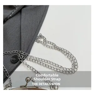 Detail of silver chain strap and gray fabric bag with white hand-stitched seams