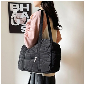 Detailed view of black quilted heart pattern on large nylon crossbody shoulder bag