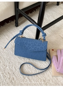 Μπλε ορθογώνια τσάντα με υφή animal print και δετό χερούλι σε βελούδινο χαλί