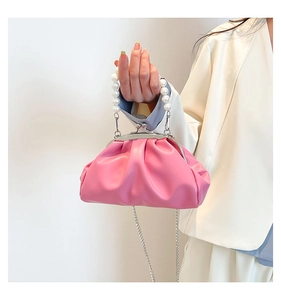 Detail of bright pink ruched cloud bag featuring elegant pearl handle and silver chain