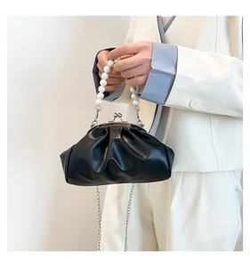 Detail of black pleated cloud bag featuring pearl handle and silver chain strap