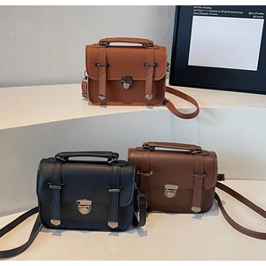 Trois sacs à main vintage en cuir noir, caramel et marron foncé sur un support à étages