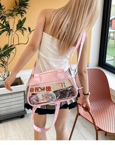 Pink PU ita bag with clear window showing anime badges and adjustable shoulder strap