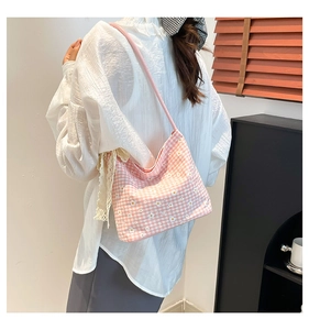 Détails d'un sac hobo à carreaux roses avec breloques en dentelle et motifs floraux