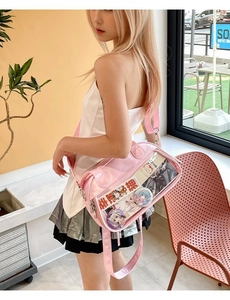 Pink ita bag with large transparent window displaying anime badges and cute cat card