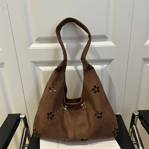Brown suede hobo bag with laser-cut hollow flower patterns and vintage tote design
