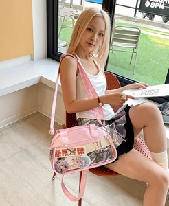 Pink Japanese Ita bag with transparent window and adjustable strap shown on model in cafe
