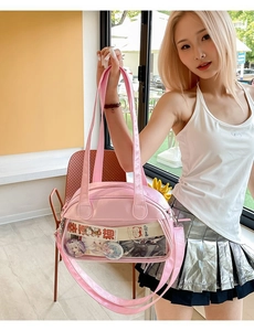 Detail of pink ita bag with transparent window showing badges and decorative items