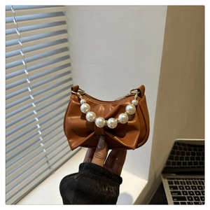 Bruine mini onderarmtas met grote strikdecoratie en handvat van parelketting