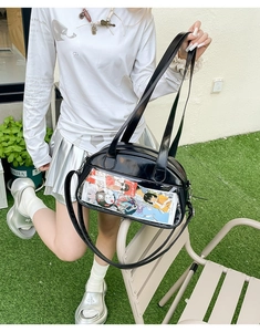 Outdoor shot of a black PU leather ita bag with a clear display window and long straps
