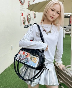 Detail of black crossbody bag featuring a transparent front pocket and clear PVC window