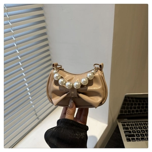 Beige mini handtas met grote strik en elegante parel handgreep voor een chique look
