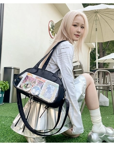 Detail of black crossbody ita bag featuring clear PVC window for anime badge display