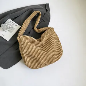 Detailed texture of light brown corduroy tote bag styled with blazer and magazines