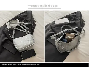 Detail showing high-capacity interior of silver pleated crossbody bag with metal chain strap
