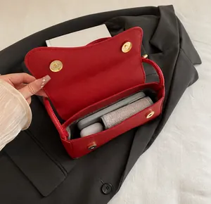 Binnenaanzicht met grote capaciteit van rode kunstleren tas voor telefoon en lippenstift